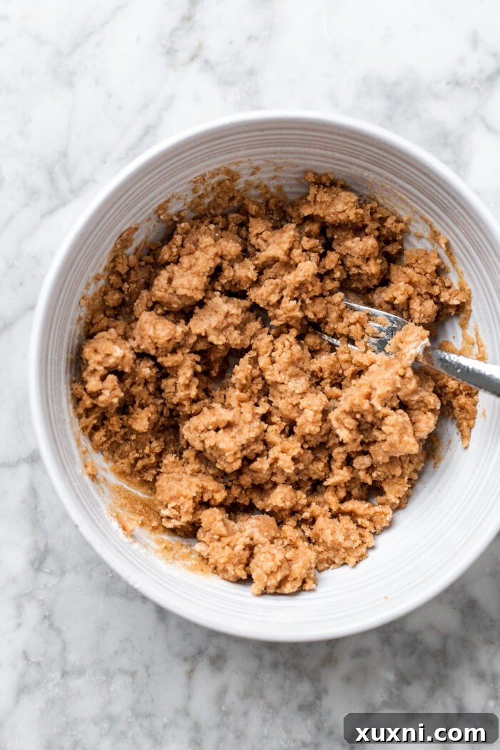 A bowl filled with freshly made cinnamon crumble topping, showing its rich, crumbly texture.