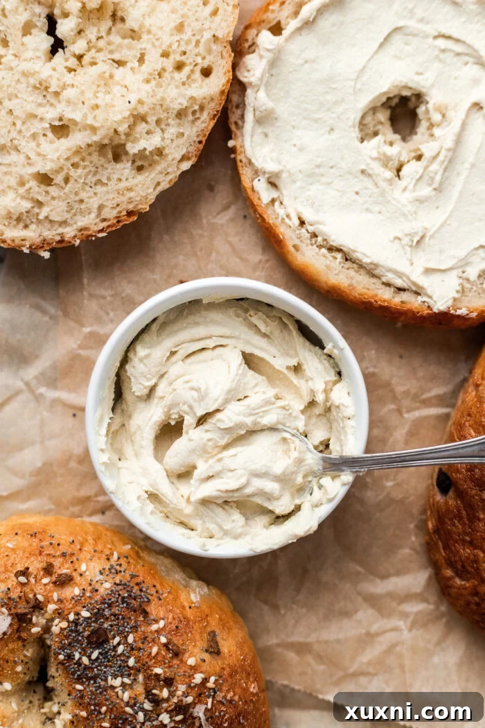 Rich and creamy homemade vegan cream cheese in a bowl, served alongside freshly baked bagels, ready to be enjoyed.
