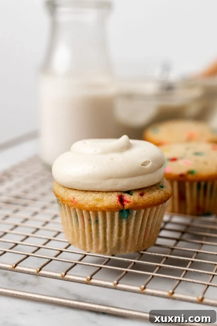 Another perfectly frosted vegan cupcake, showing the smooth texture and appealing appearance of the cream cheese frosting.