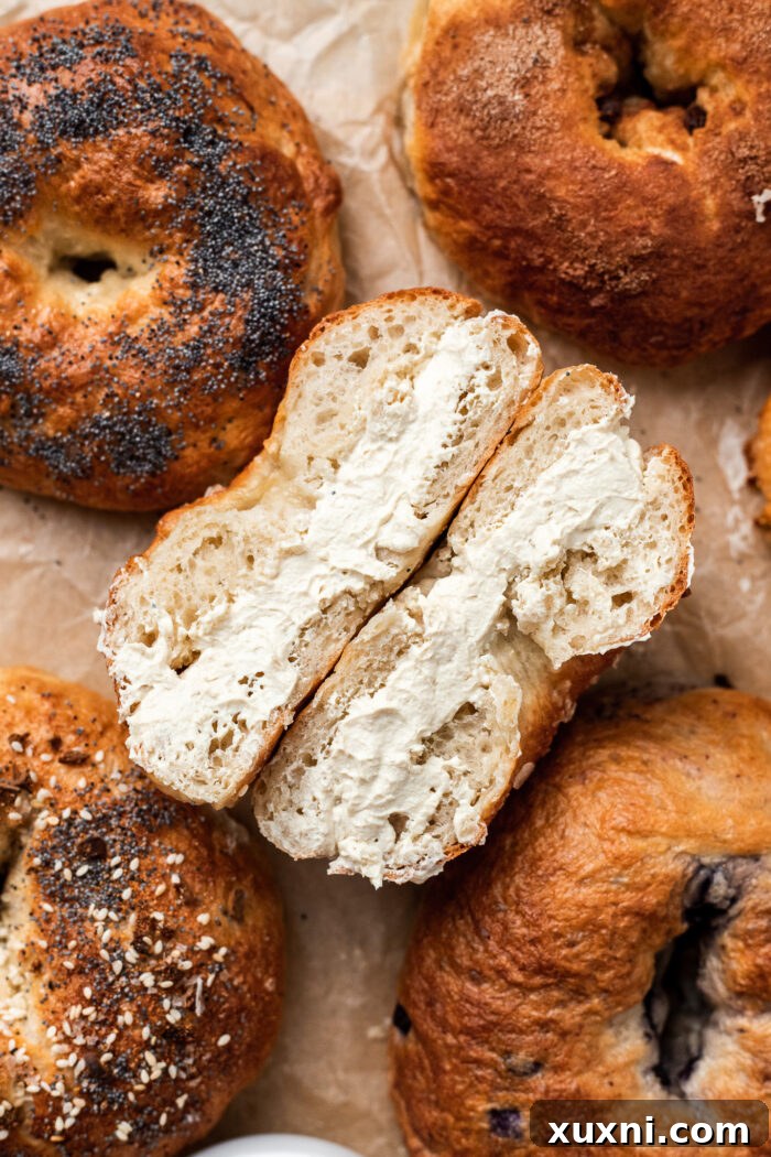 Freshly toasted vegan bagels generously spread with homemade vegan cream cheese, placed on a serving board.