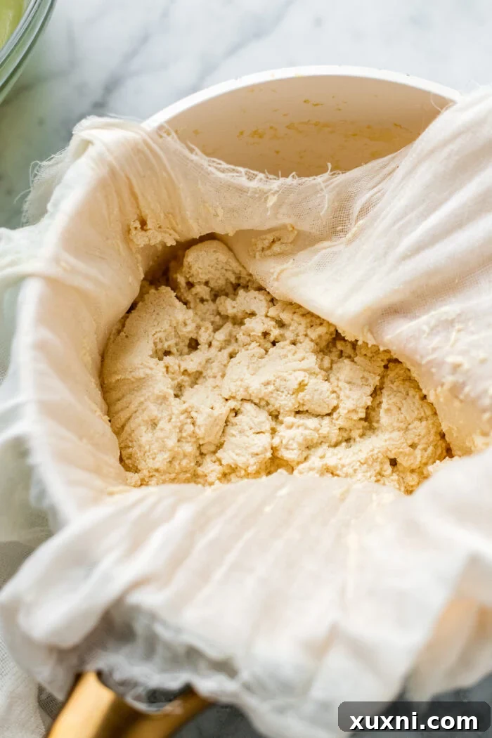 The initial stage of making vegan cream cheese, showing pea milk being prepared in a saucepan.