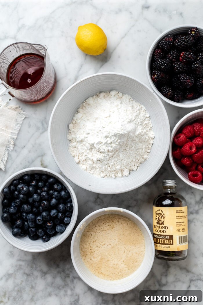 A flat lay of the individual ingredients for berry crumble bars, including flour, maple syrup, vegan butter, cornstarch, and mixed berries.
