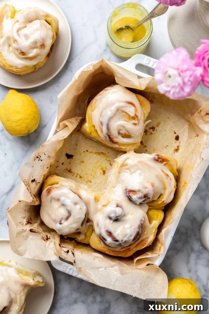 Small Batch Gooey Lemon Sweet Rolls Plant Based 4 A tray of freshly baked vegan lemon sweet rolls, glistening with a creamy white frosting.