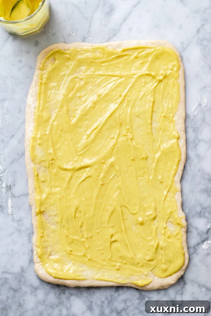 Small Batch Gooey Lemon Sweet Rolls Plant Based 10 The lemon curd being spread evenly over the dough, ready for slicing and rolling into sweet rolls.