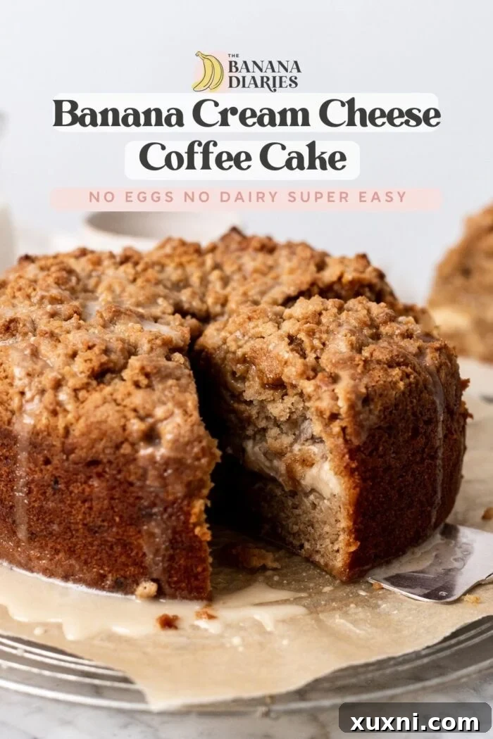 A beautifully sliced vegan banana crumb cake, highlighting the layers and golden crumb topping.