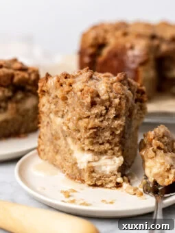 Slice of banana crumb cake on a plate, showcasing the layers and texture.