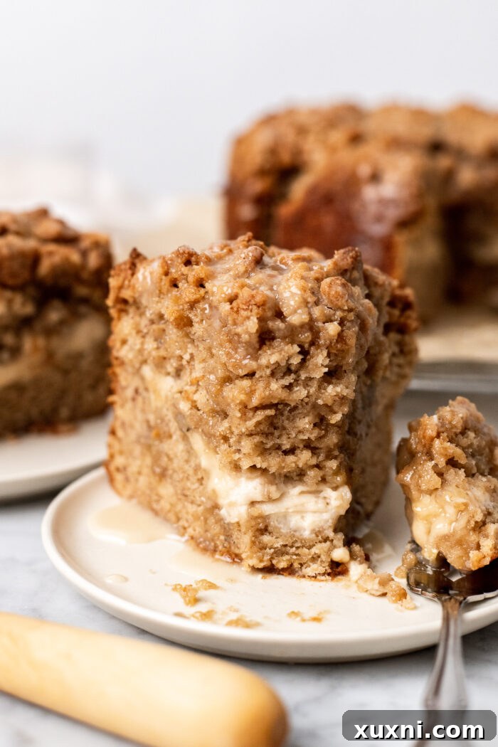 A delicate slice of banana crumb cake on a pristine white plate, ready to be enjoyed.