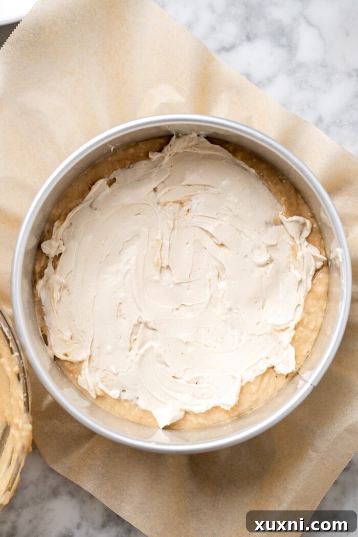Cream cheese layer spread evenly over the banana coffee cake batter in the pan.