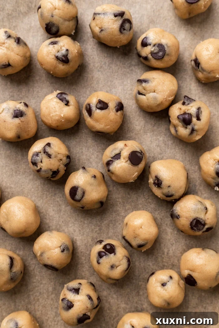 Easy No-Bake Vegan Brownie-Cookie Dough Cheesecake Bars 6 cookie dough balls on a baking sheet