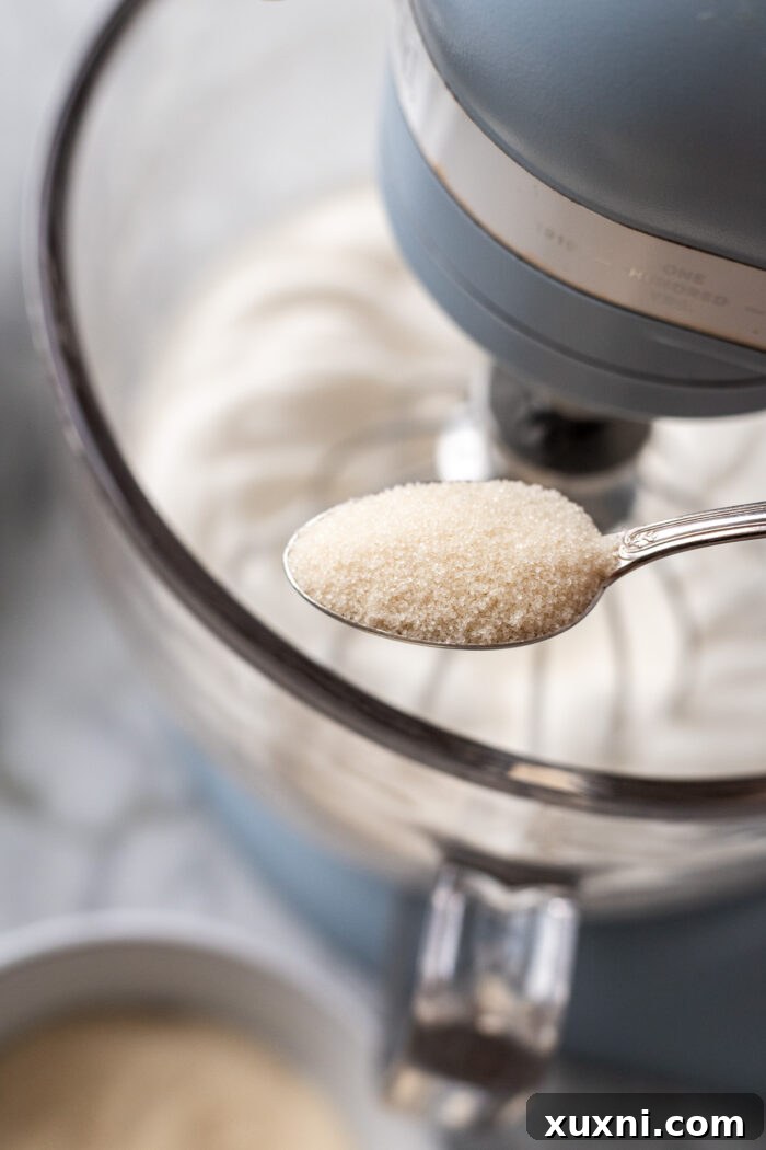 Heavenly Vegan Angel Food Cake 8 Slowly adding granulated sugar into the foamy aquafaba meringue during whipping.