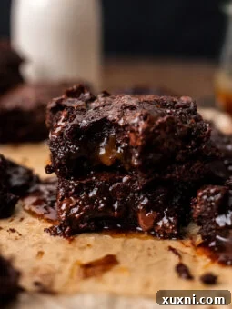 Stacked vegan salted caramel brownies with a glossy top