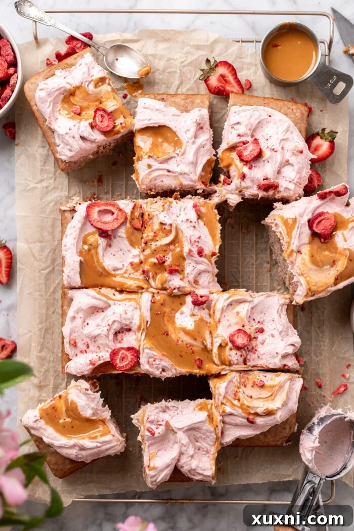 sliced vegan strawberry cake showcasing the peanut butter swirl and vibrant pink frosting