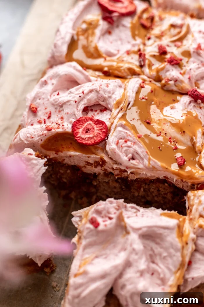 sliced strawberry sheet cake on parchment paper, ready to be served