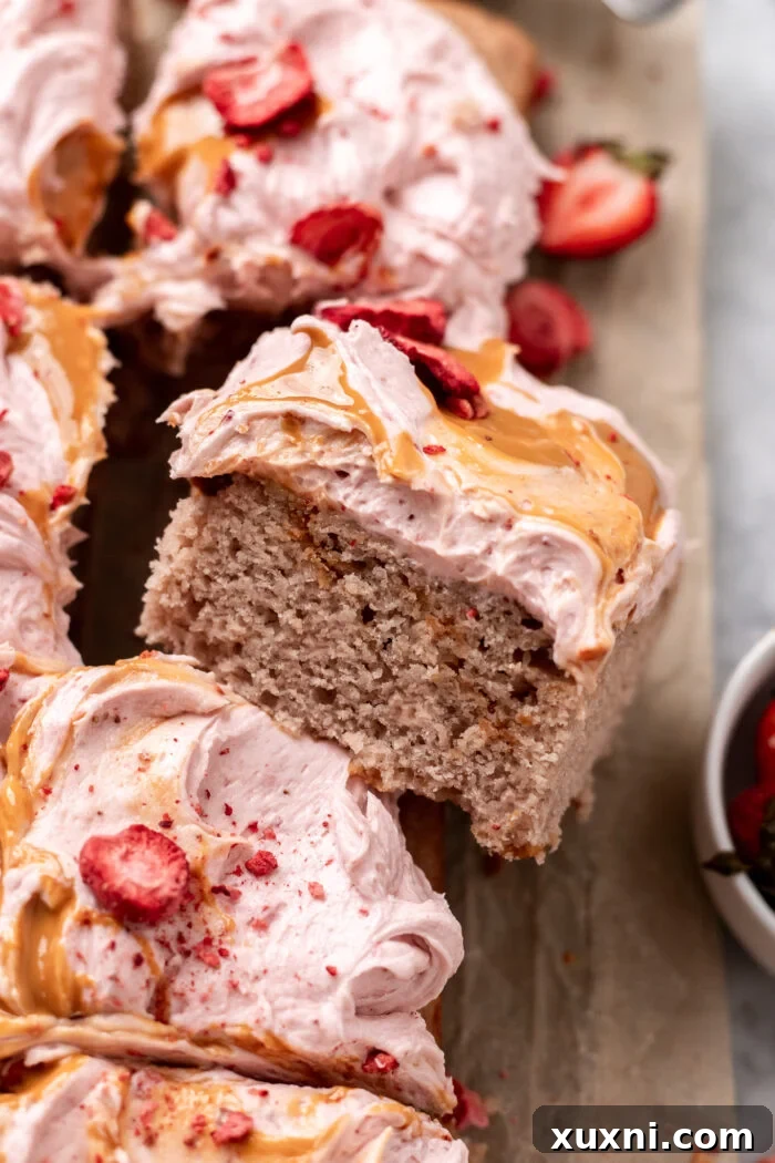 slice of strawberry sheet cake leaning on another slice, highlighting the cake's texture