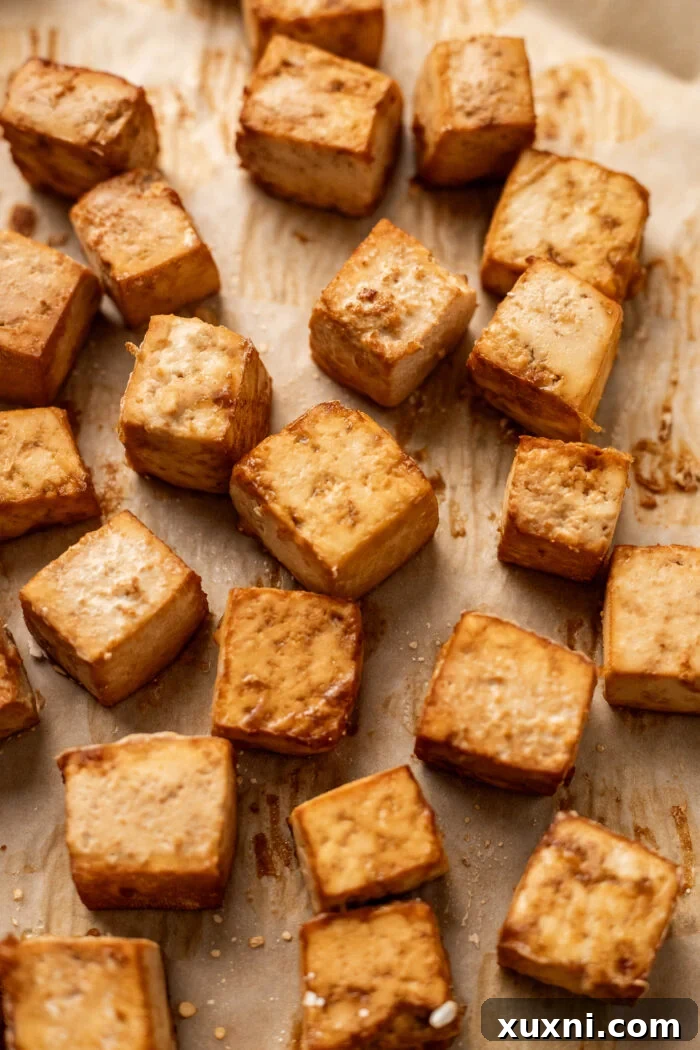 A close-up view of perfectly crispy baked tofu, showing its textured, golden surface.
