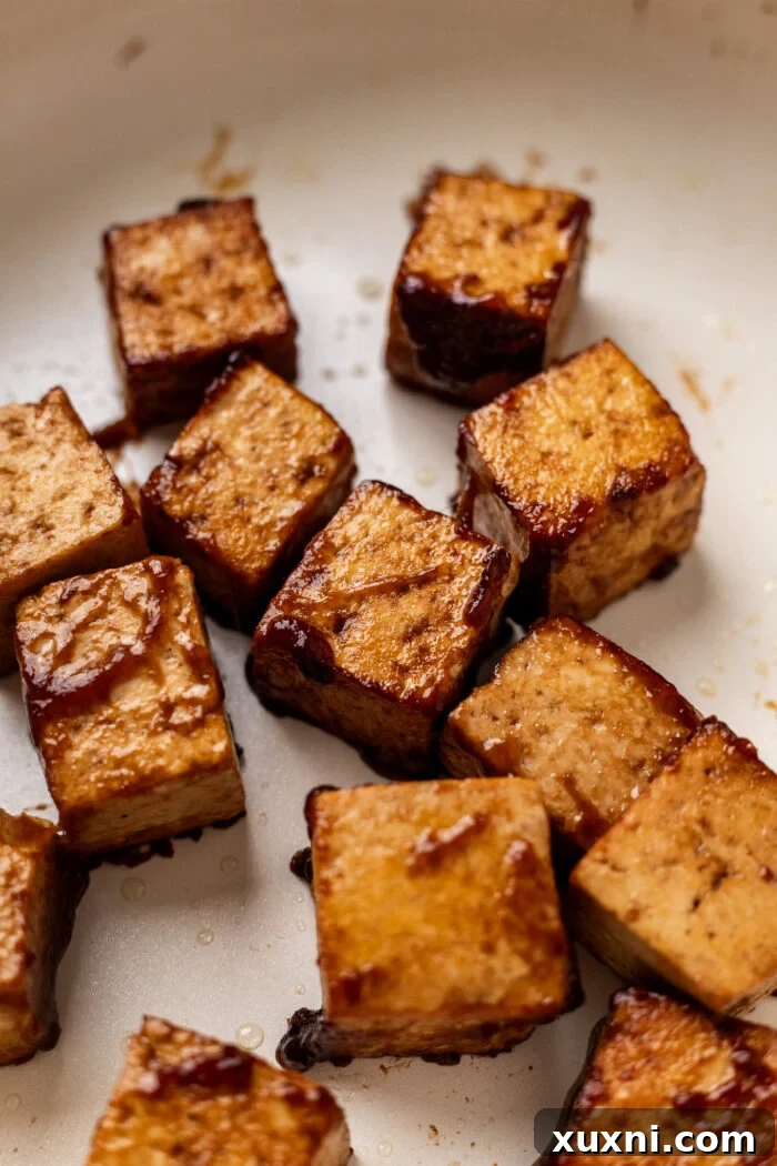 A vibrant plate of crispy tofu served with fresh greens and a light drizzle of sauce, making for a healthy meal.