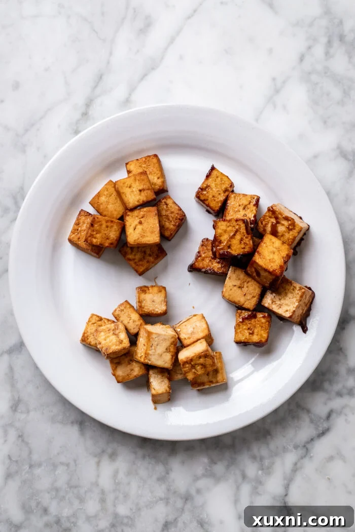A diverse assortment of crispy tofu, prepared using three distinct cooking methods: baked, air-fried, and sautéed.