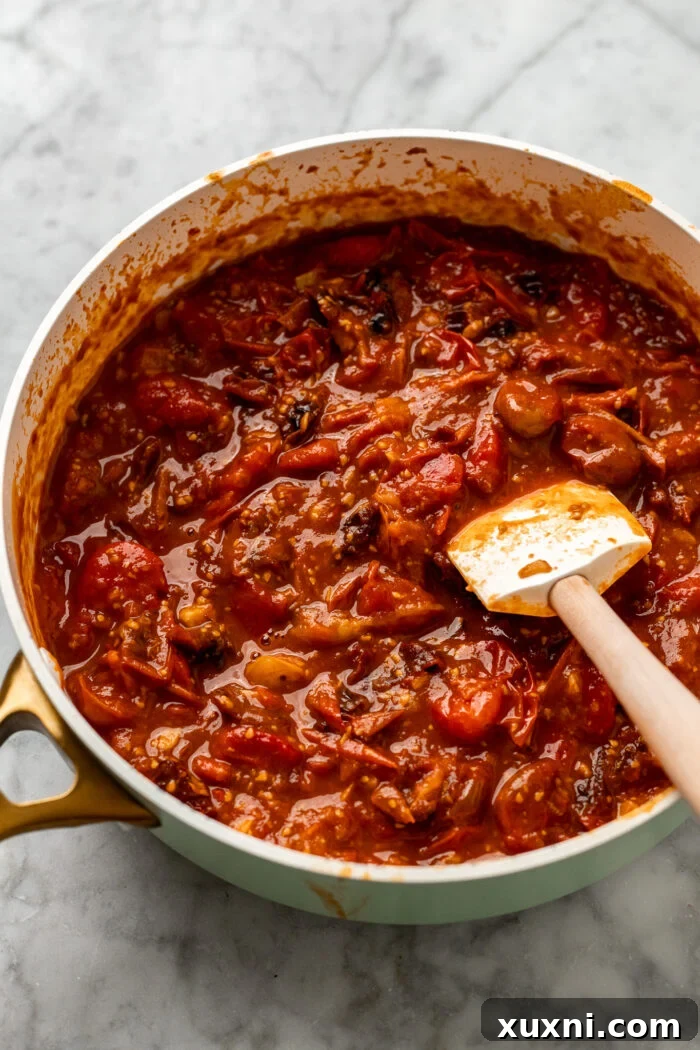 Close-up of freshly cooked homemade cherry tomato sauce in a pan, vibrant and rustic.