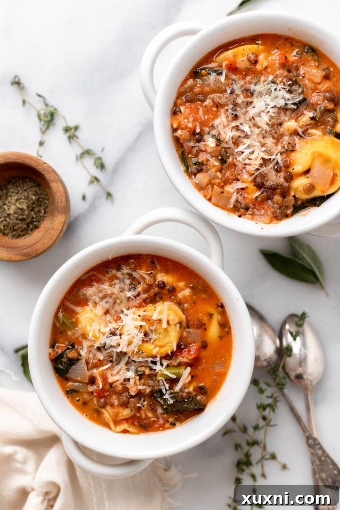 Two cozy bowls of creamy vegan tortellini soup on a rustic wooden table, garnished with fresh herbs, inviting warmth and comfort.