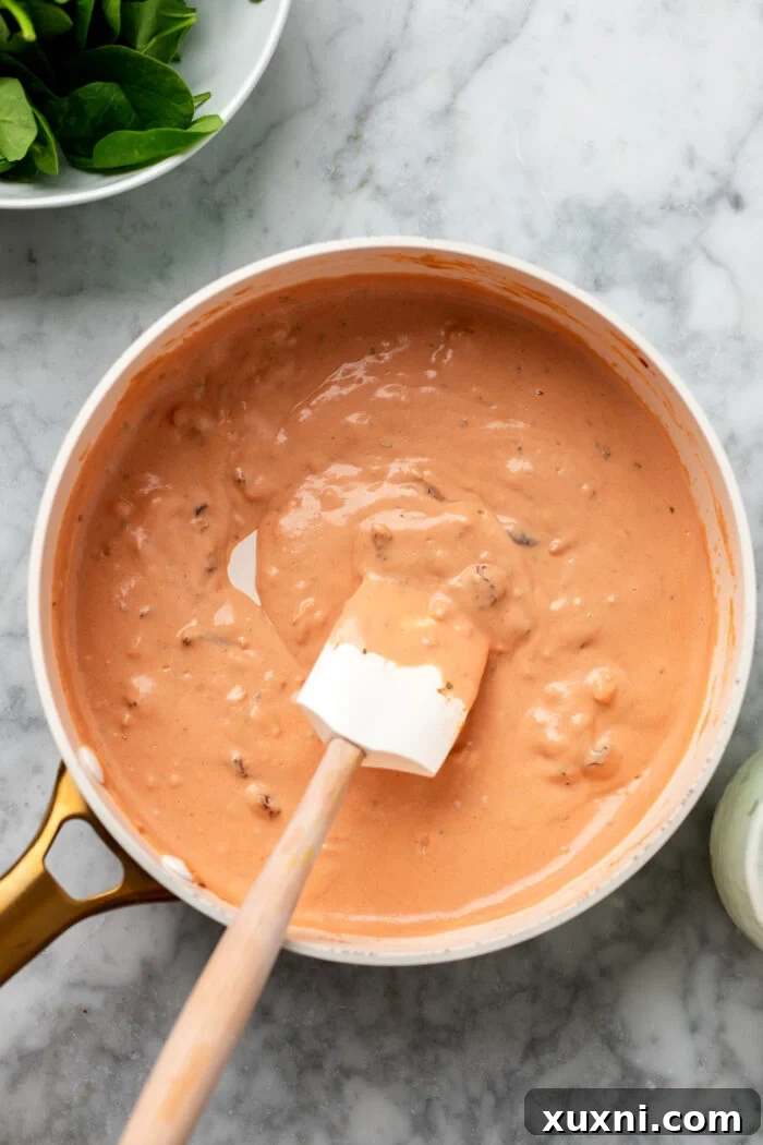 adding in the sun-dried tomatoes and reducing the sauce