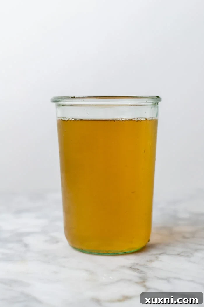 Glass container of golden vegetable stock