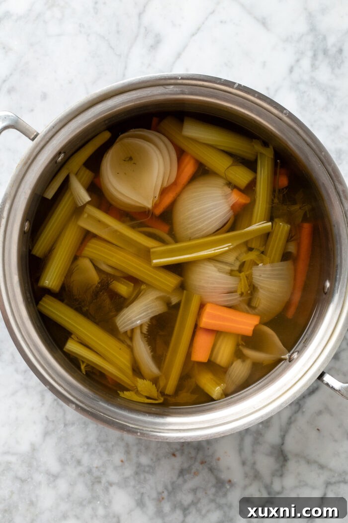 Vegetable broth simmering in a large pot on the stovetop