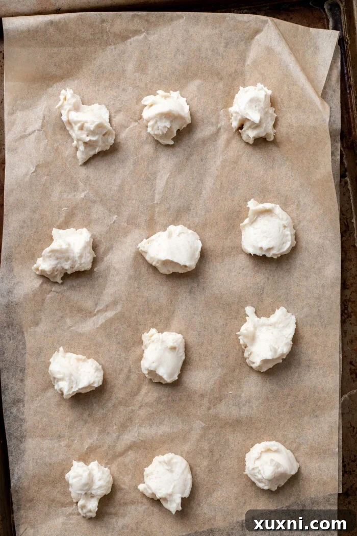 cream cheese scooped onto baking sheet