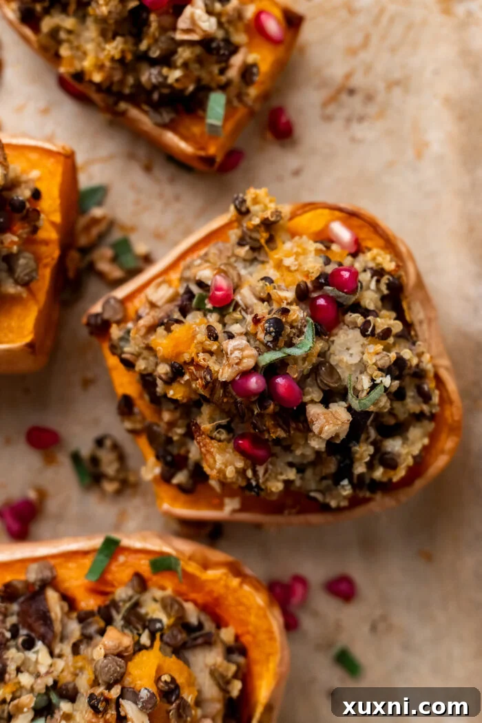 Two halves of beautifully roasted and stuffed butternut squash, garnished with fresh herbs, on a rustic baking sheet, ready to be served.