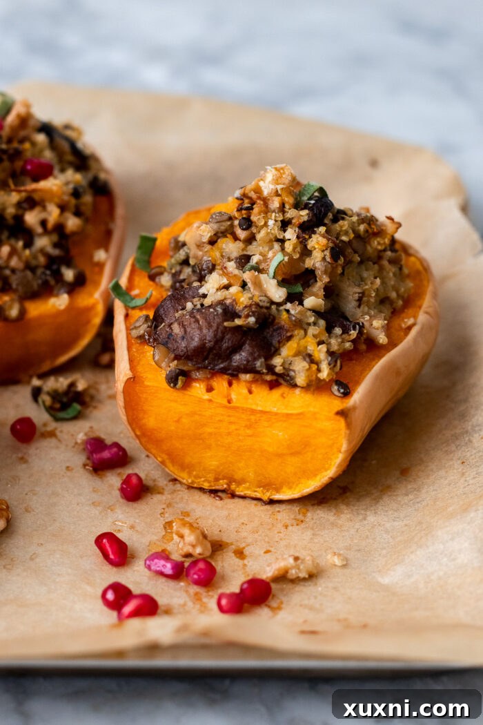 Close-up of golden roasted butternut squash halves on a baking sheet, ready to be filled with savory stuffing.