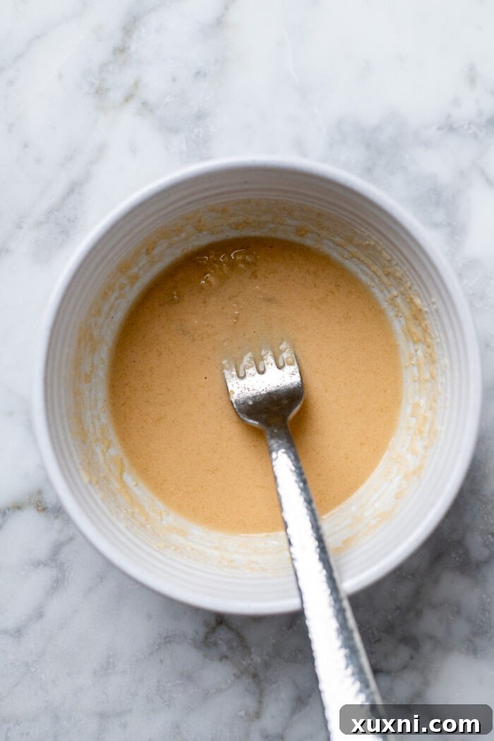 A small bowl containing the whisked cashew sauce ingredients, ready to be added to the stuffing mixture.