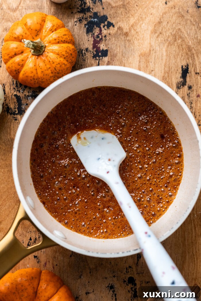 Homemade butterscotch sauce simmering in a saucepan.