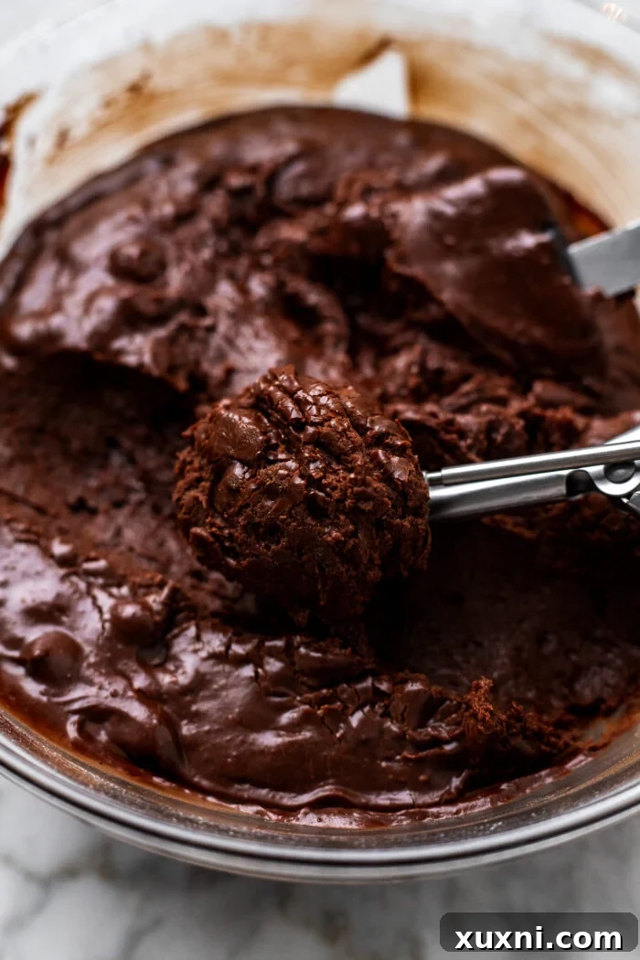 Effortless Fudgy Vegan Brownie Cookies 9 Scooping the brownie cookie dough with a cookie scoop onto parchment paper