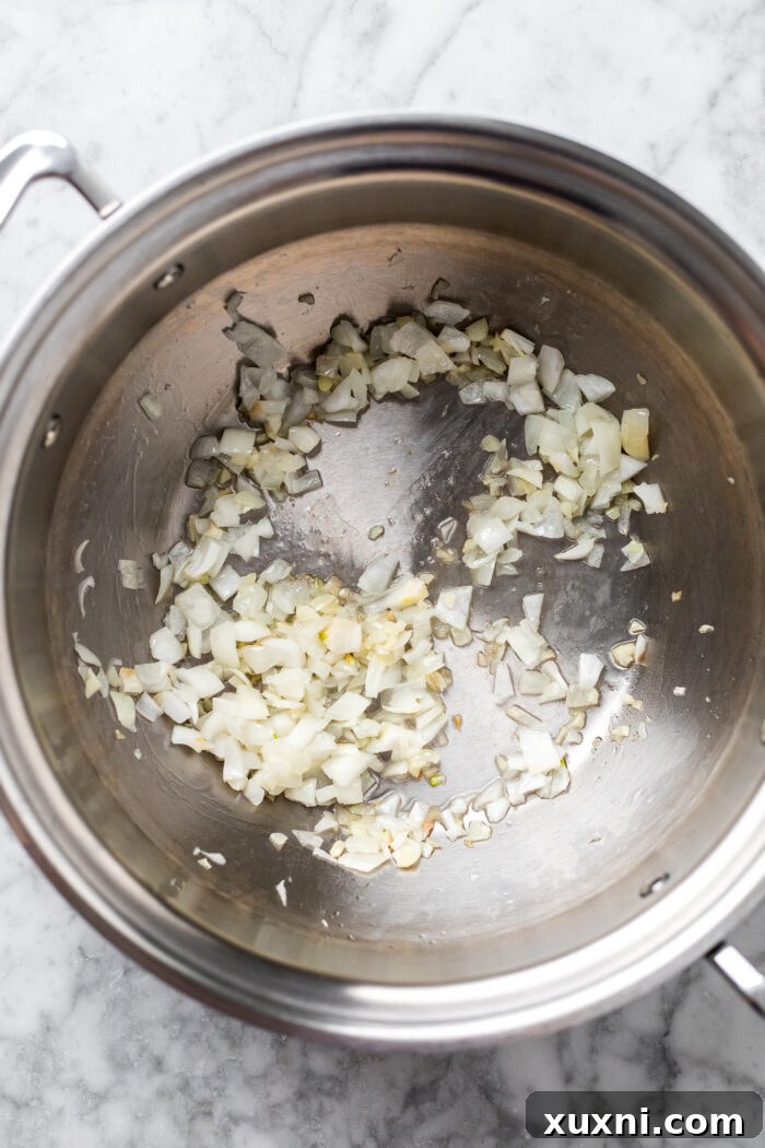 Creamy Peanut Butter Sweet Potato Curry with Chickpeas and Kale 6 Sautéing the finely minced garlic and chopped onions in coconut oil within a large pot to build a fragrant base.