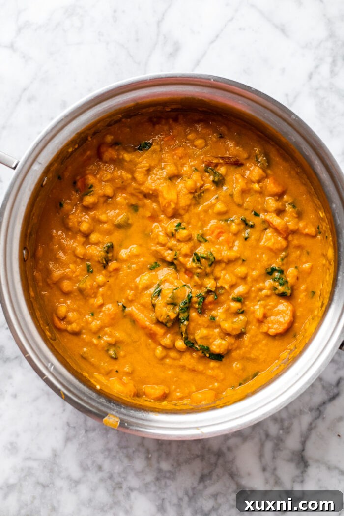 Creamy Peanut Butter Sweet Potato Curry with Chickpeas and Kale 10 The fully cooked and thickened sweet potato curry in the pot, showcasing its rich, creamy consistency.