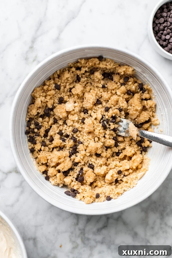A bowl filled with a delightful crumb topping mixture, ready to be sprinkled over the coffee cake, showing its perfectly coarse texture.