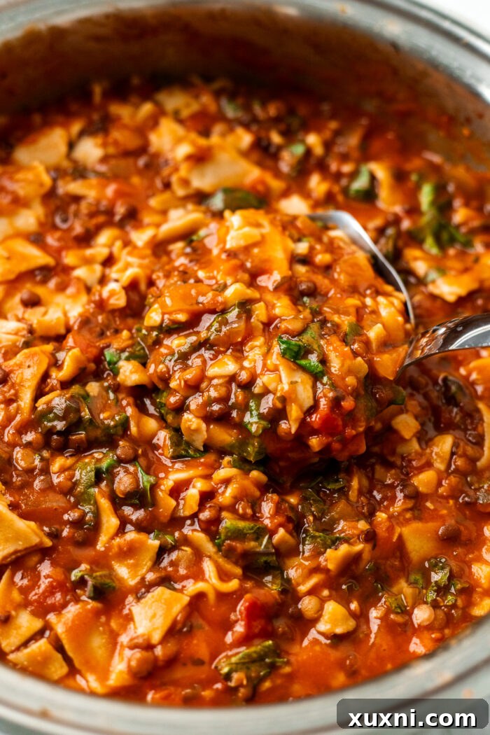 spoon scooping lasagna soup from pot