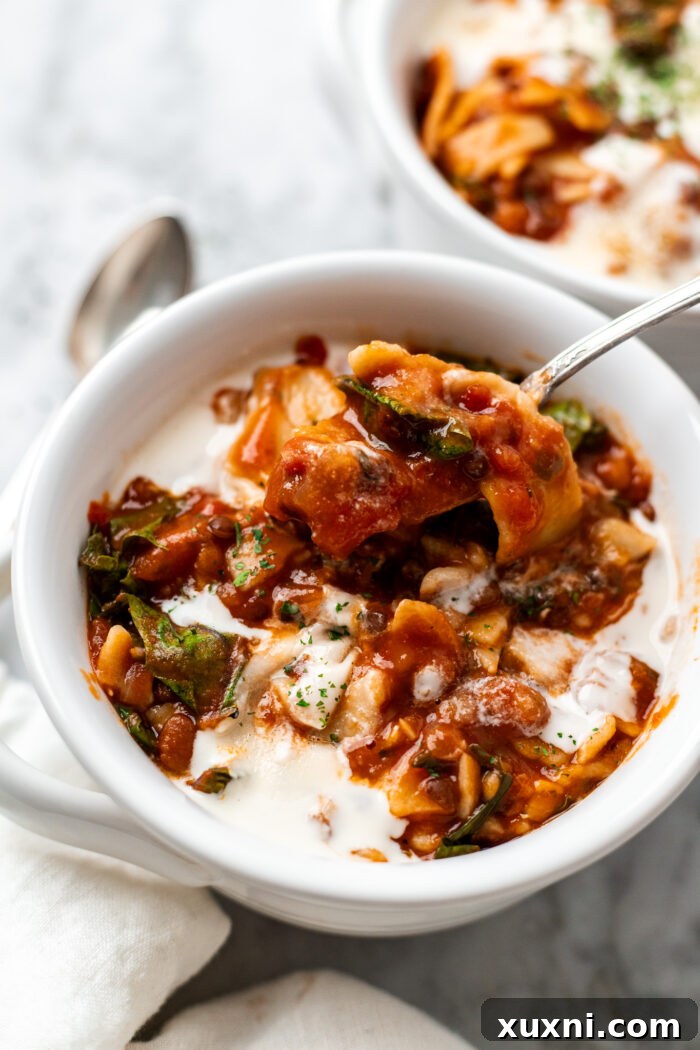 vegan lasagna soup in a bowl with vegan cheese
