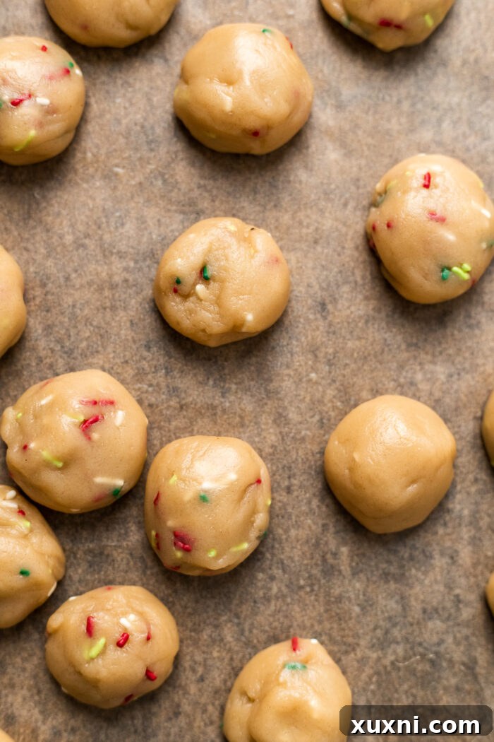 scooped cookie dough balls on a baking sheet