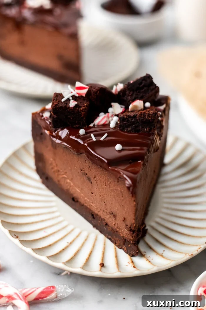 A perfectly sliced piece of vegan chocolate peppermint cheesecake on a white plate, highlighting its elegant layers.