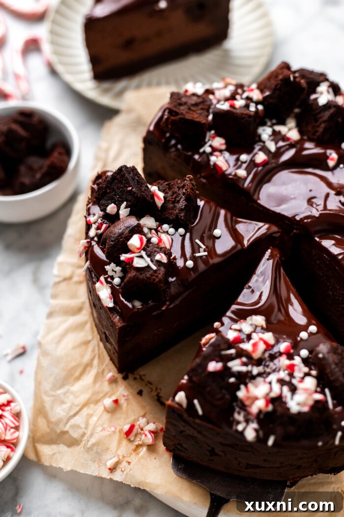 A stunning close-up of a full vegan chocolate peppermint brownie cheesecake, showcasing its elegant layers and toppings before slicing.