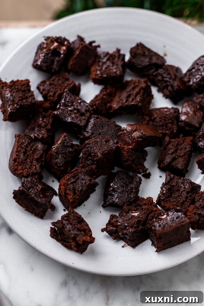 A plate piled high with small, fudgy brownie bites.