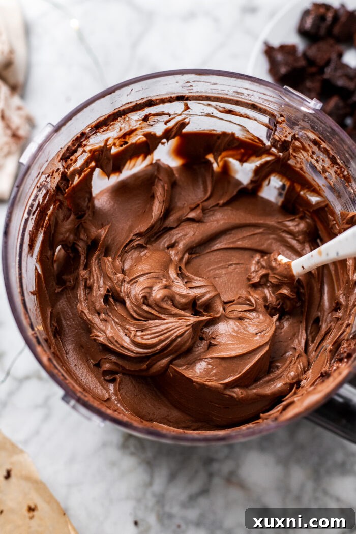 Creamy chocolate peppermint cheesecake batter in a food processor.