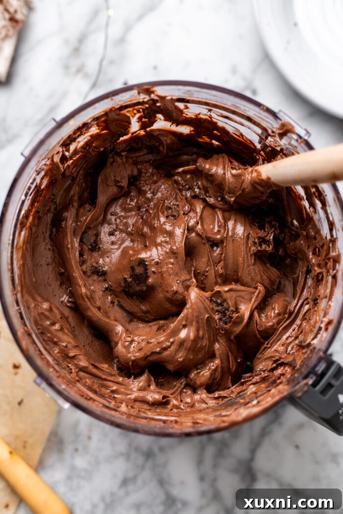 Cheesecake batter with brownie bites folded in, ready to be poured.