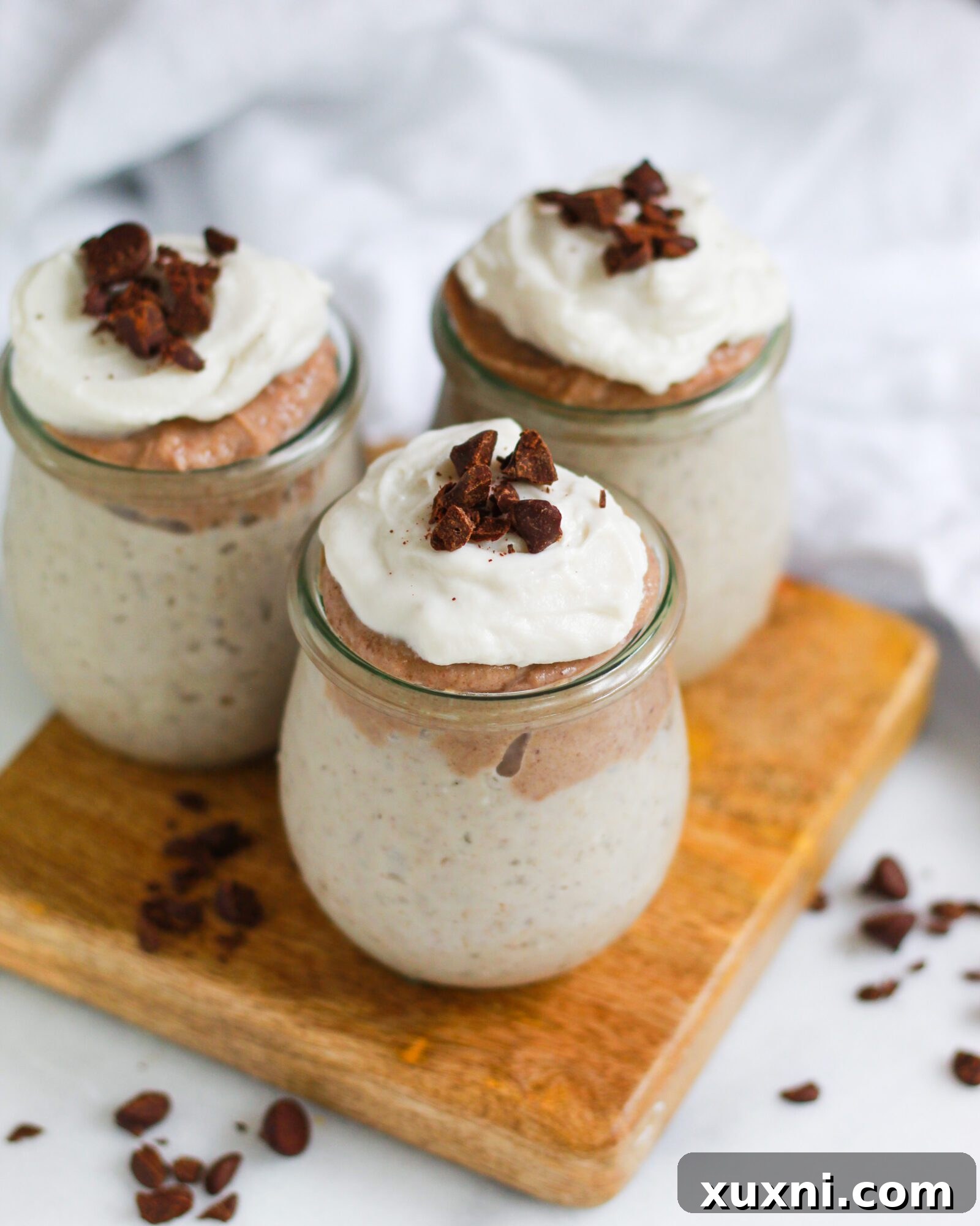 A rustic wooden board holds a serving of vegan butterscotch pudding, highlighting its natural elegance and inviting appeal.