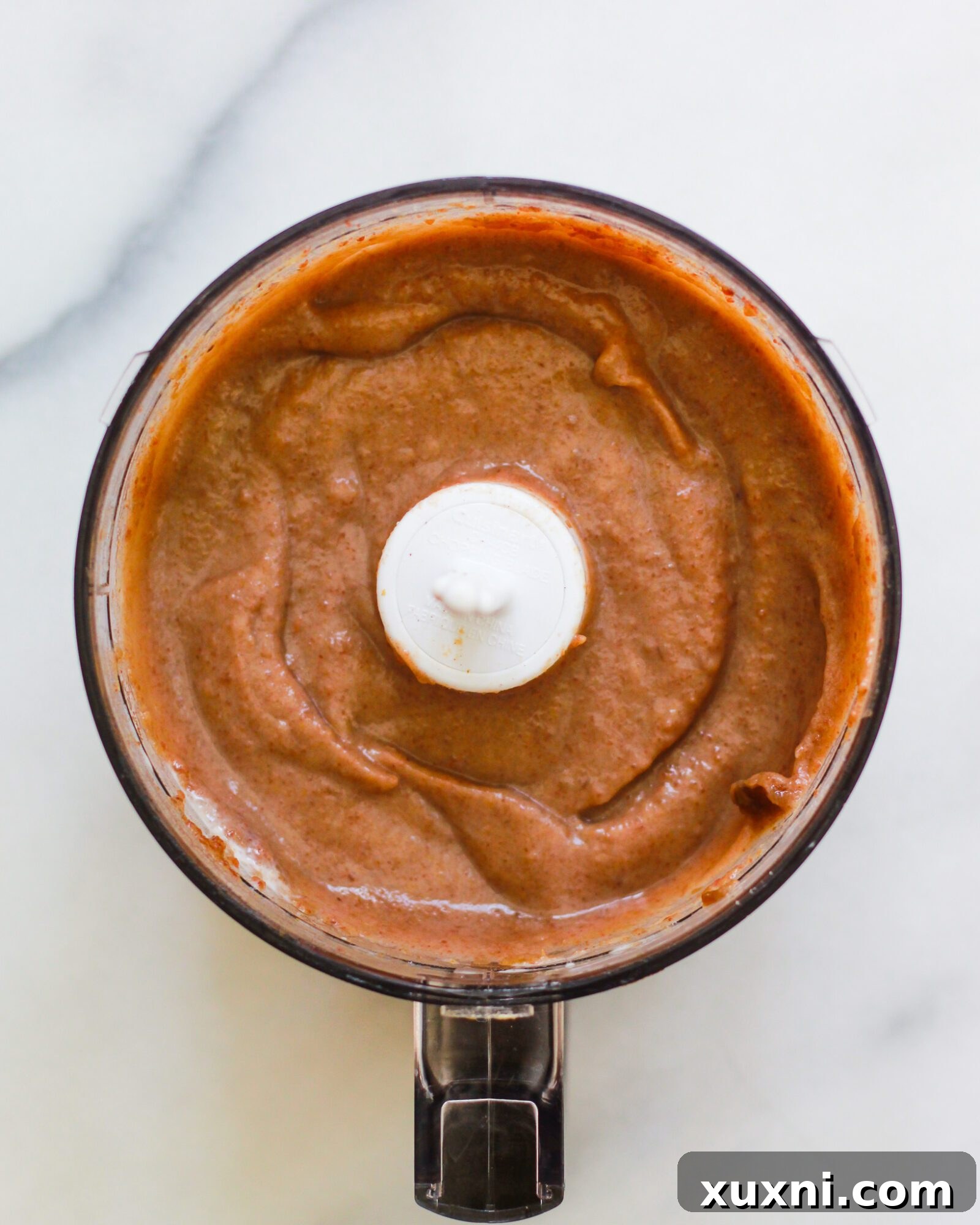 Homemade salted date caramel sauce being blended to a smooth perfection in a food processor, capturing its creamy texture.