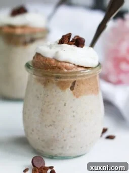 A jar of homemade vegan butterscotch pudding topped with coconut whipped cream, showcasing its appealing texture and presentation.