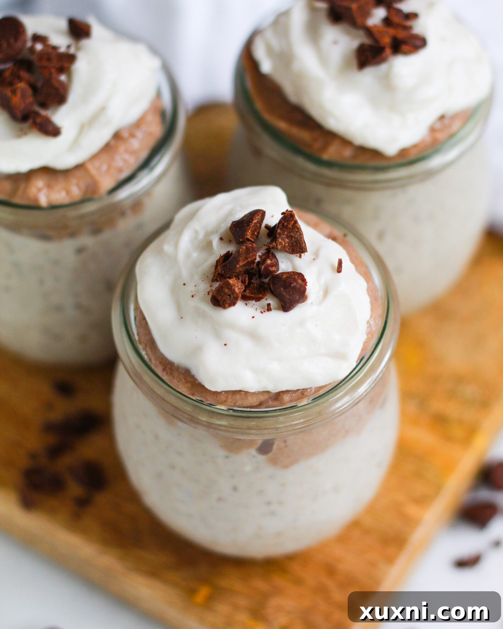 A close-up view of a serving of classic vegan butterscotch pudding, adorned with mini chocolate chips, emphasizing its creamy richness.