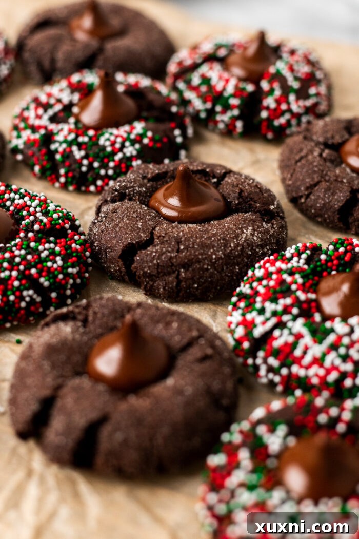 Baked vegan chocolate blossoms cooling on a wire rack with chocolate kisses pressed into them.