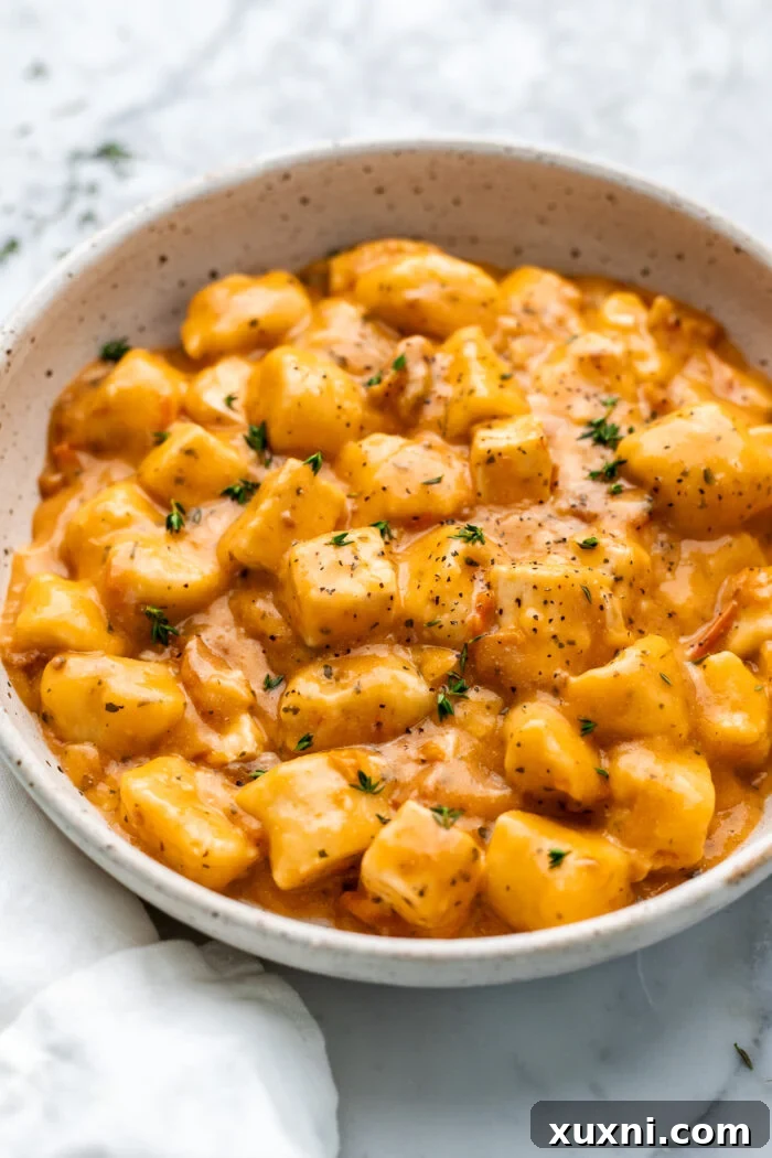 bowl of vegan marry me tofu and gnocchi with fresh basil, ready to eat