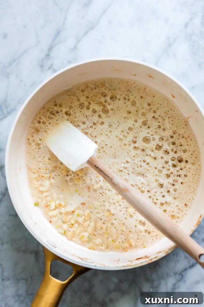 sautéing minced garlic in a pan with sun-dried tomato oil